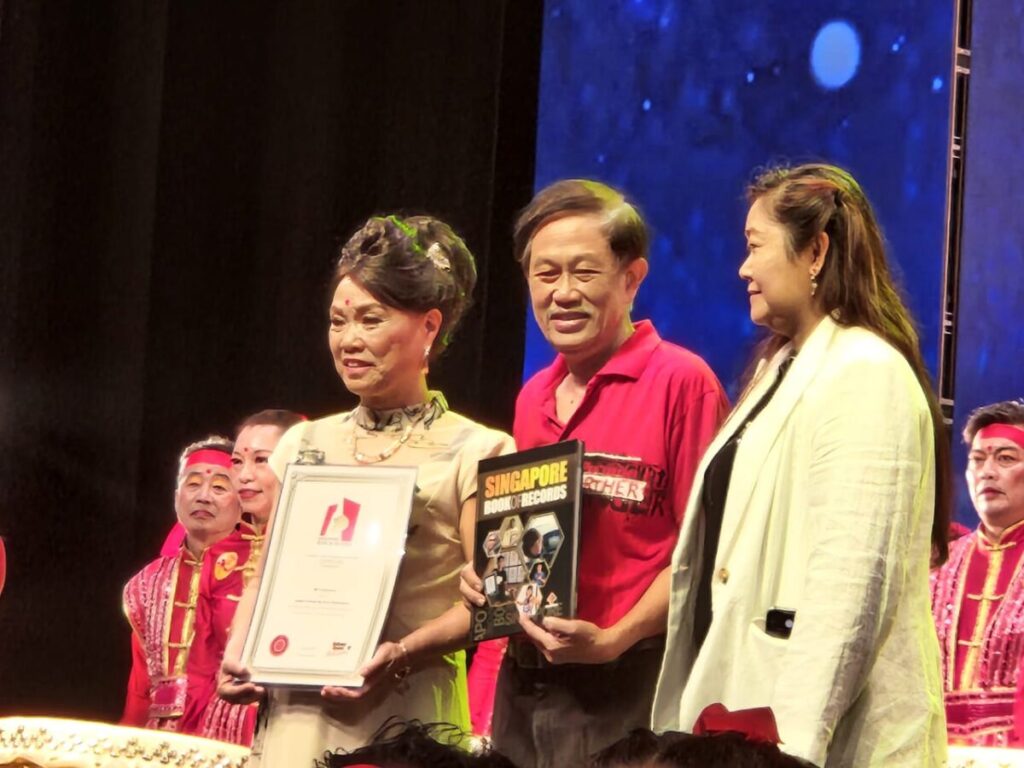 《光艺盛典》荣获新加坡最多击鼓人演出奖，新加坡纪录大全负责人颁发证状予白世音(左)。